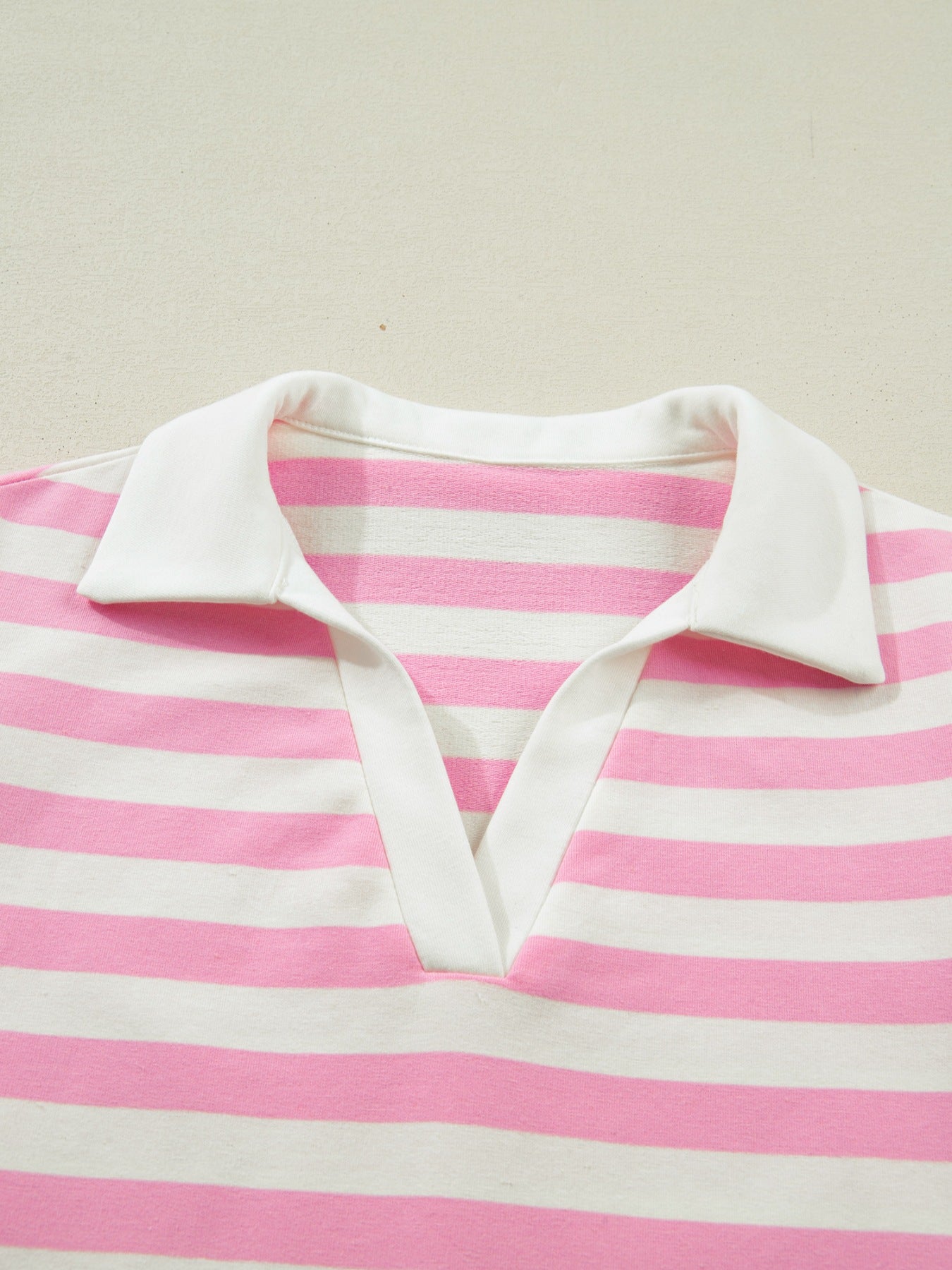 Pink and white striped cotton blouse with a white collar and V-neck detail.