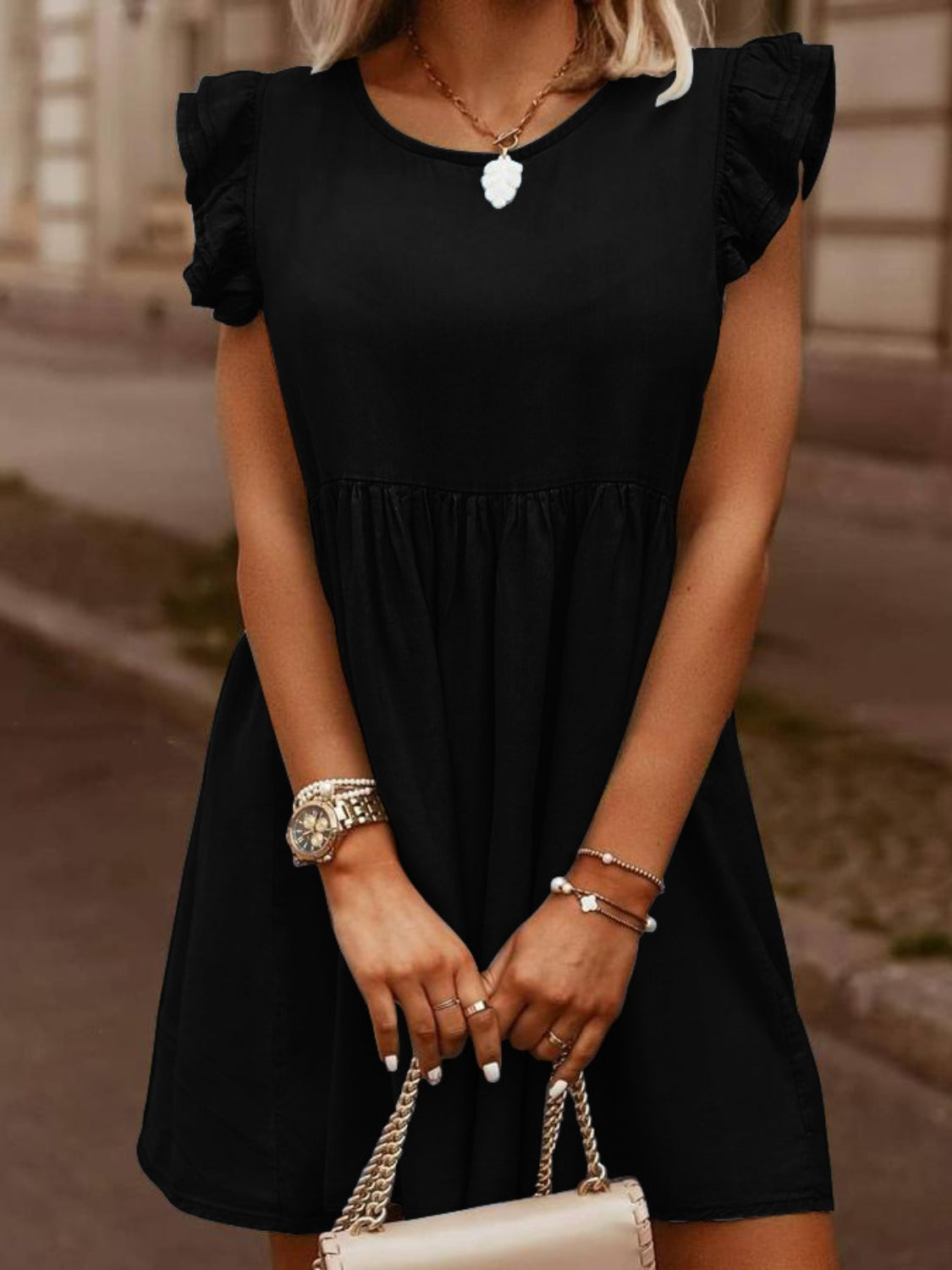 Black denim babydoll dress with ruffled short sleeves and a gathered waist.