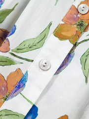 Cotton button-up shirt with vibrant floral print, v-neck detail, and ruffled accents.