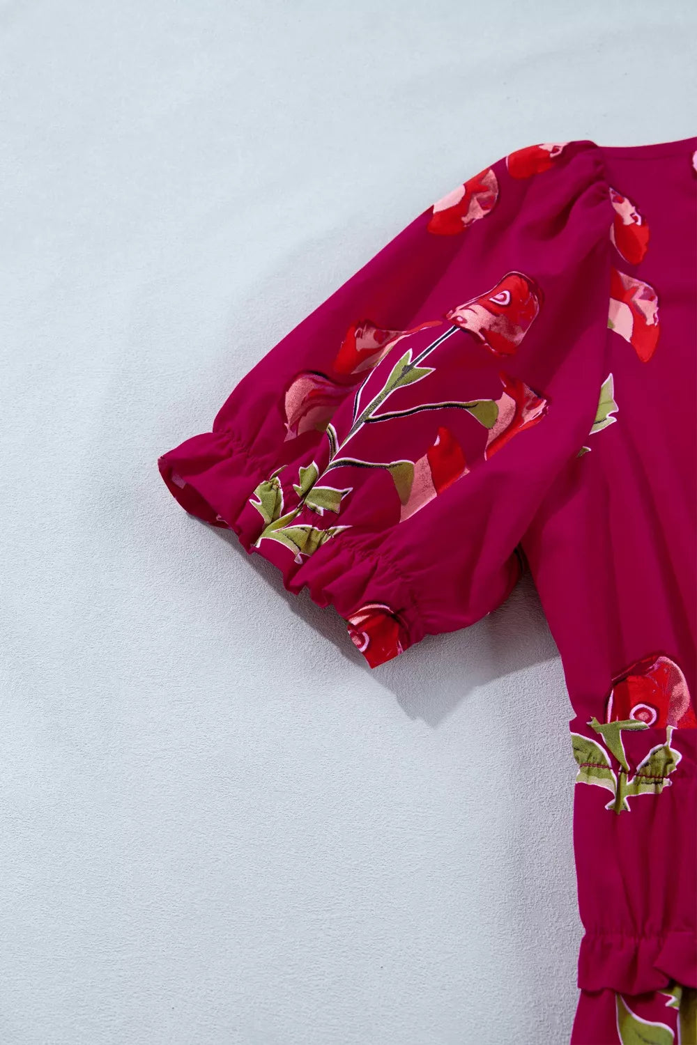 Charming floral tiered midi dress in magenta with puff sleeves and ruffled cuffs.