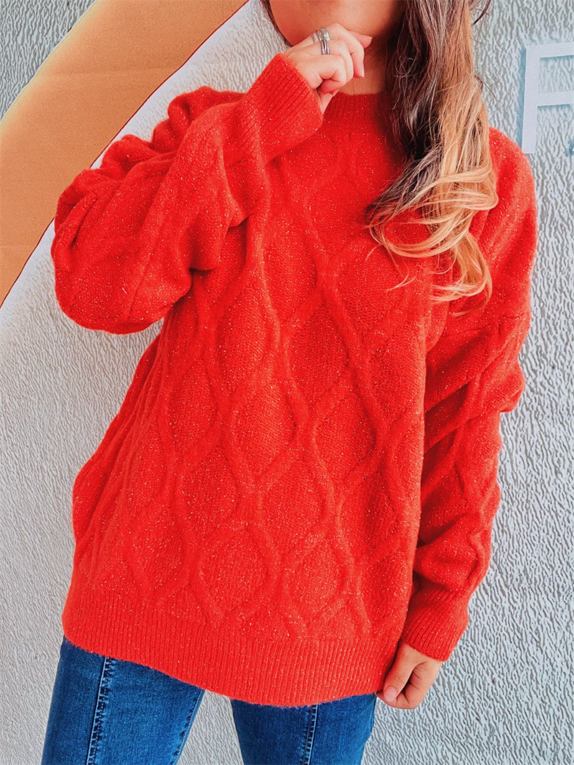 Orange-red sparkle knit sweater with diamond cable knit pattern and relaxed fit.