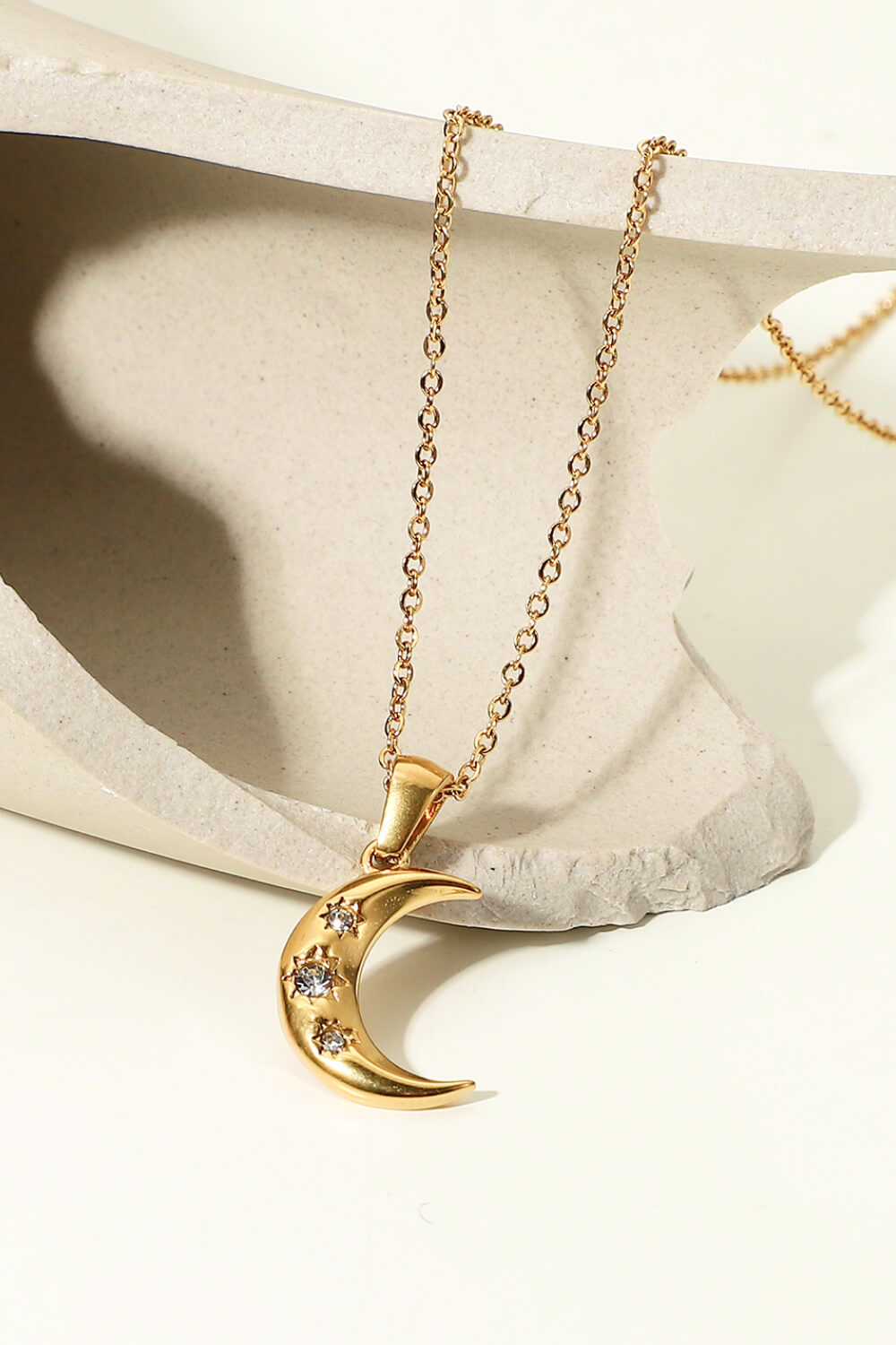 Gold crescent moon pendant necklace with sparkling cubic zirconia stars.