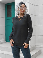Black acrylic knit sweater with buttoned keyhole neckline and long sleeves.