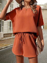 Orange waffle knit drawstring co-ord set with short sleeves and shorts.