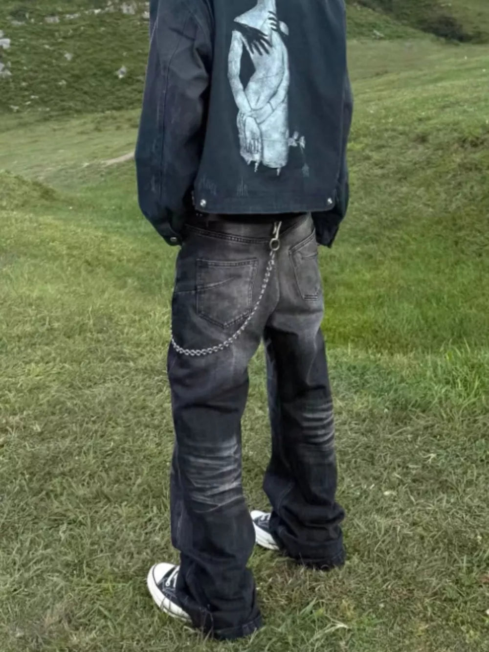 Belted dark grey wide-leg men's jeans with chain detail and pockets.