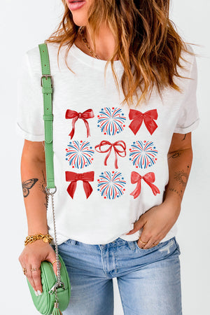 White t-shirt with red bows and red, white, and blue fireworks graphic pattern.