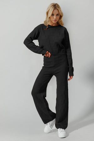 Black textured knit loungewear set with crew neck sweater and wide leg pants.