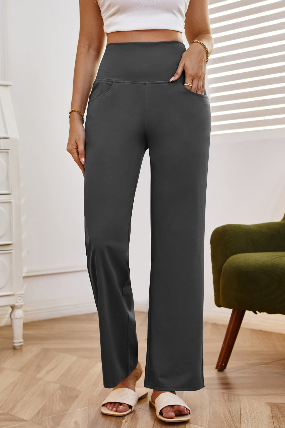 High-waisted flare leg trousers in dark gray with pockets, styled casually.