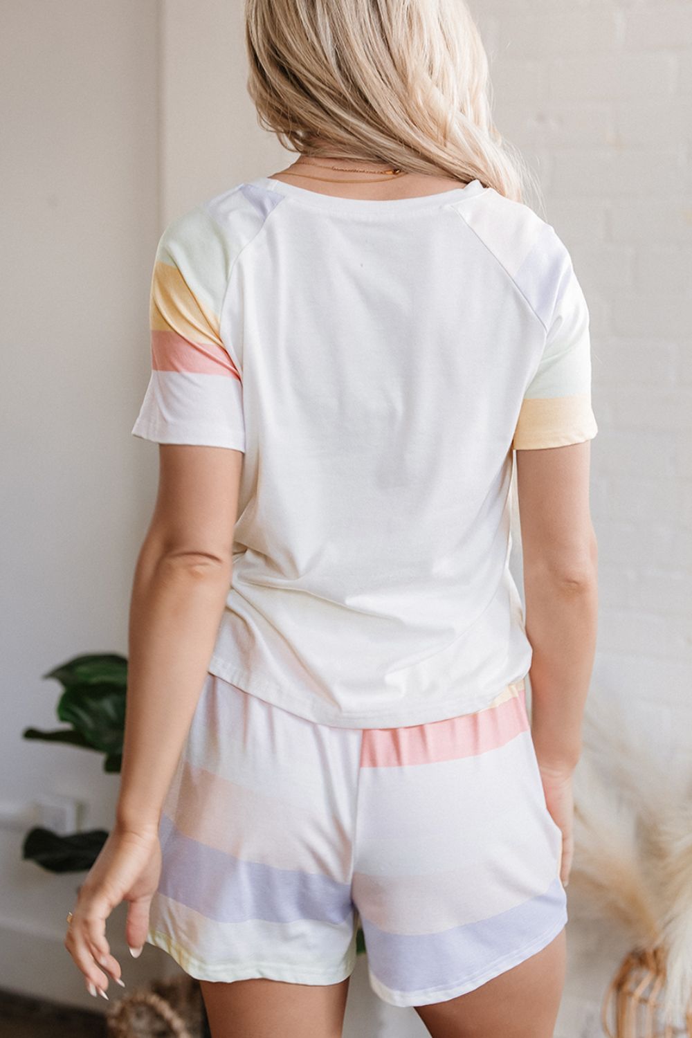 White loungewear set with pastel rainbow stripes on sleeves and shorts