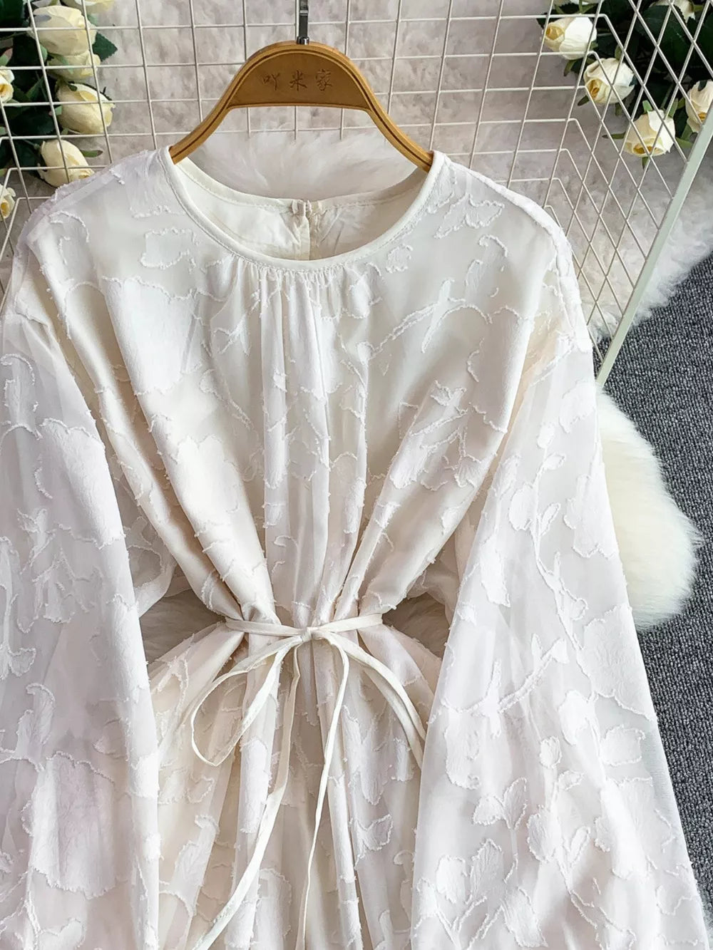 White embroidered tie-waist dress with crew neck and long sleeves.