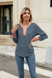 Striped long sleeve blouse with peach neckline and smocked cuffs.