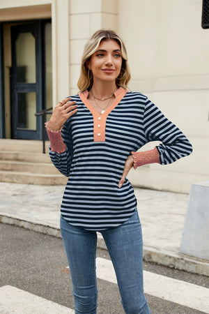 Striped long sleeve blouse with peach neckline and smocked cuffs.