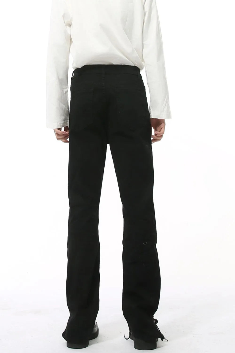 Split-hem black denim jeans with a tailored fit and subtle distressed detail.