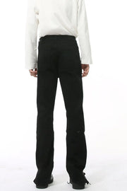 Split-hem black denim jeans with a tailored fit and subtle distressed detail.