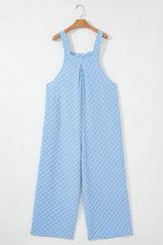 Light blue checkered textured palazzo jumpsuit with button straps and wide legs.