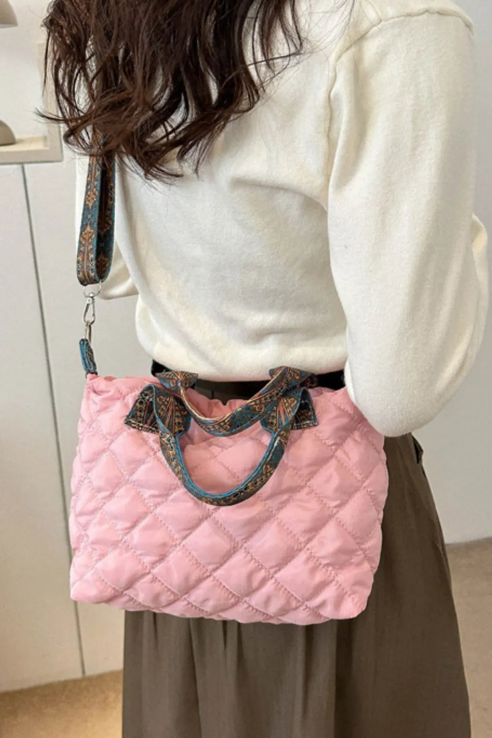 Blush pink quilted satchel bag with patterned strap and handles