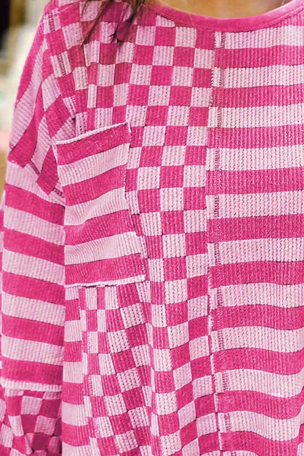 Hot pink knit top with asymmetrical checkered and striped patchwork design