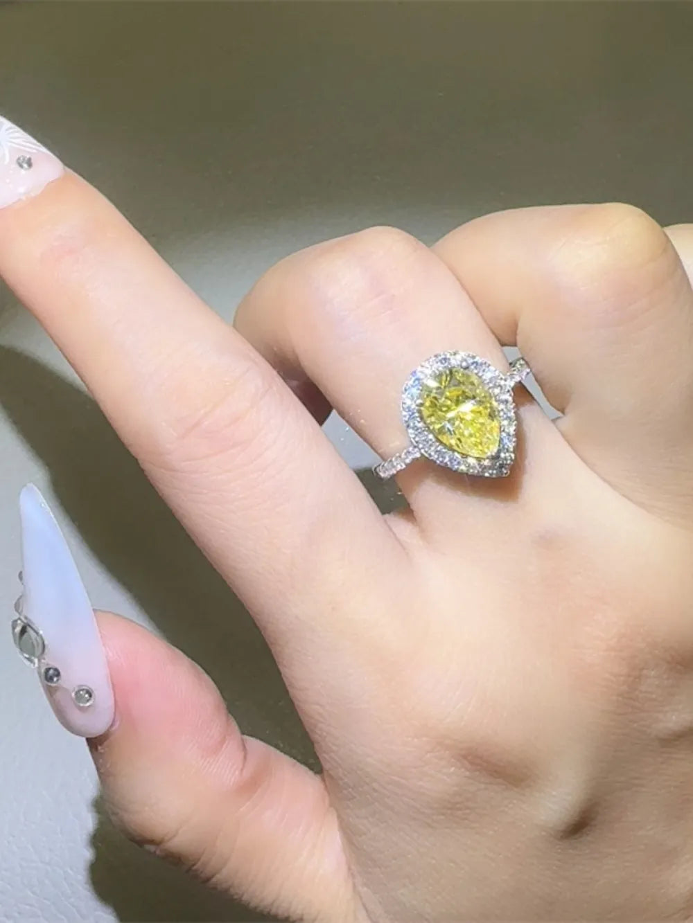 Yellow pear-cut moissanite halo ring with diamond band