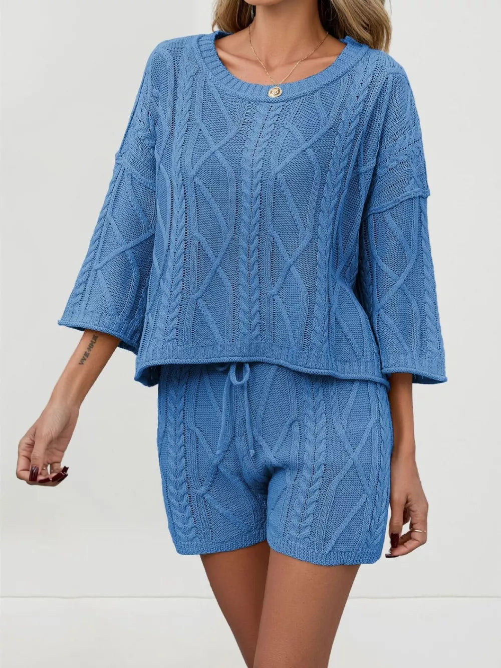Blue cable-knit two-piece sweater set with 3/4 sleeves and drawstring shorts.