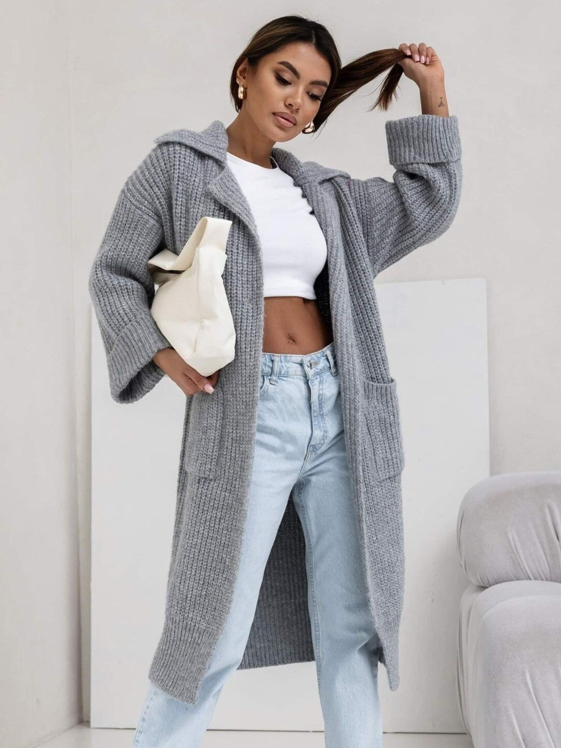 Gray oversized knit lapel cardigan with pockets and a long length.