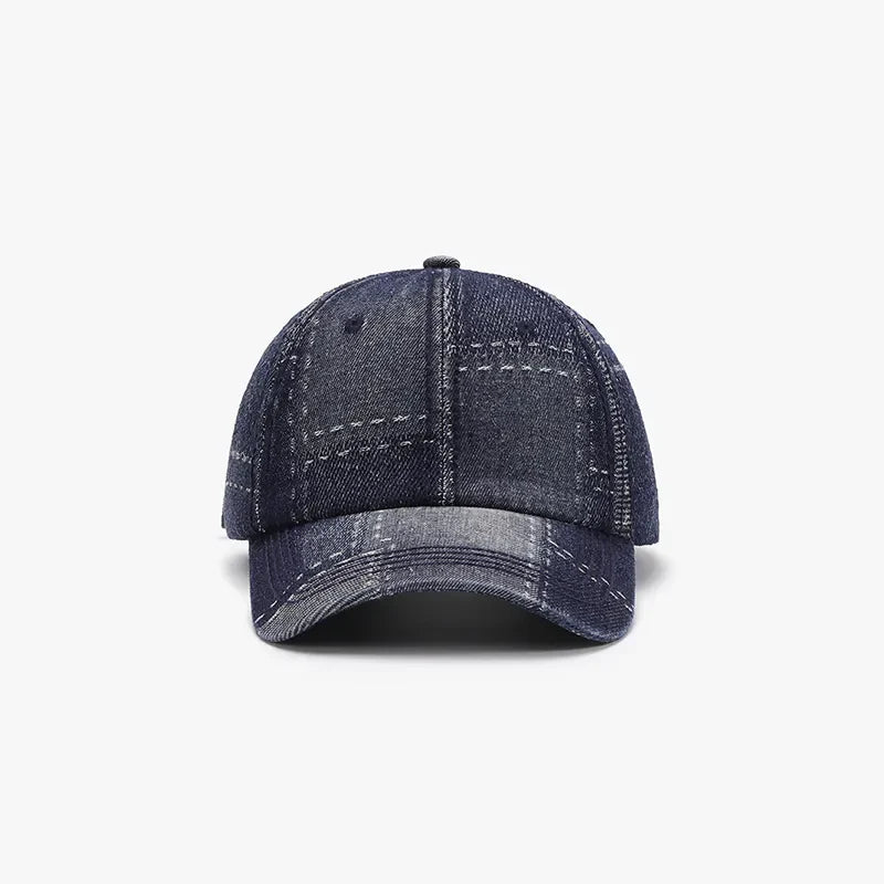 Denim patchwork baseball cap in dark wash with contrast stitching and plaid pattern.