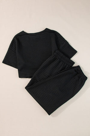 Black quilted knit crop top and jogger set with crewneck and elastic waistband.