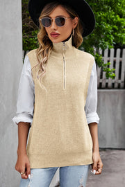 Tan ribbed knit vest with a mock neck and quarter zip, styled over a white shirt.