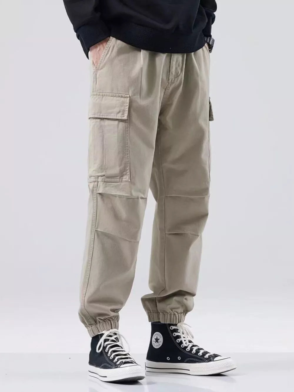 Khaki relaxed fit cargo sweatpants with elastic cuffs and multiple pockets.