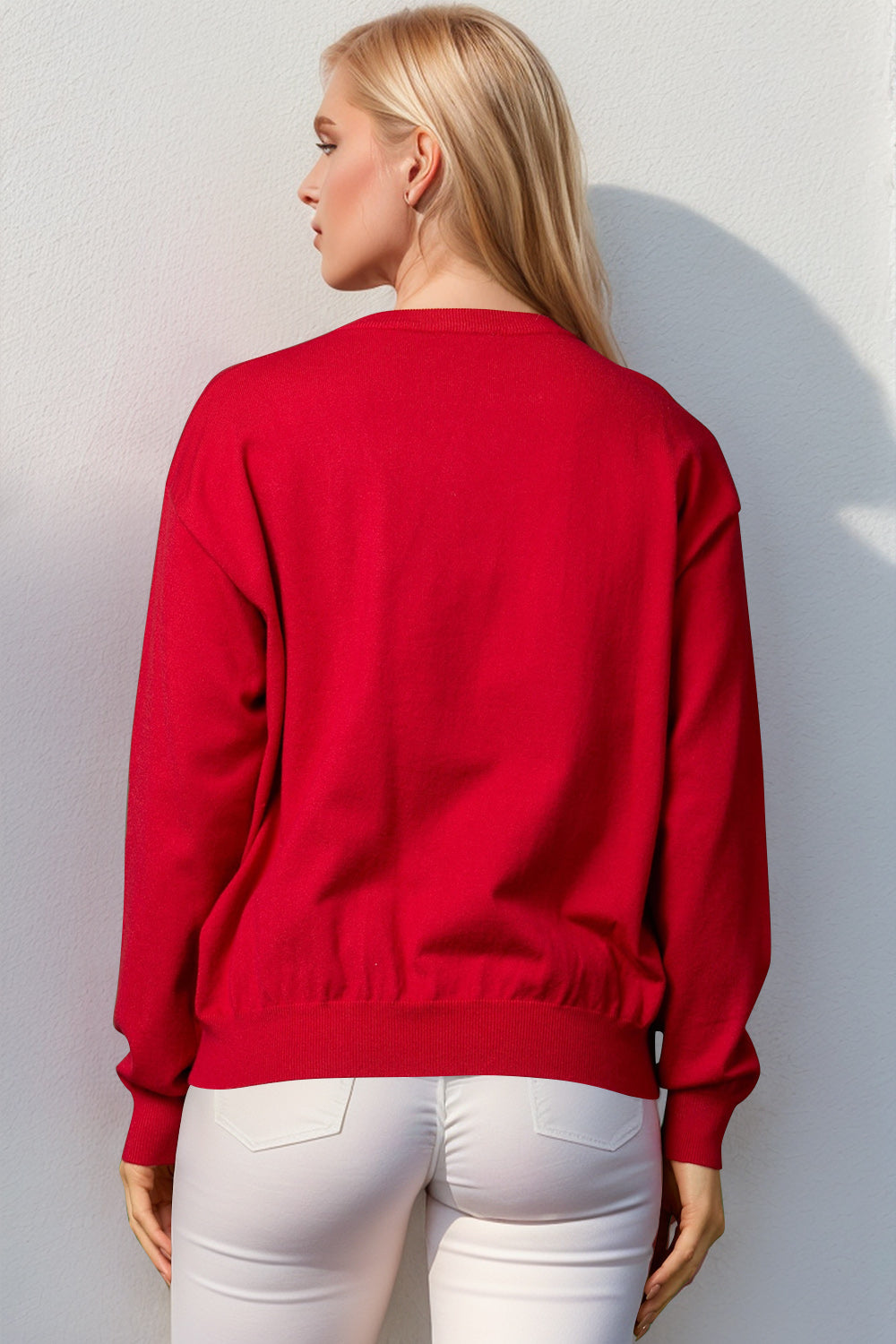 Red crewneck sweater with sequin nutcracker embellishment, acrylic knit, long sleeves, ribbed cuffs and hem.