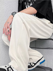 Cream wide-leg casual pants with a relaxed fit, styled with sneakers.