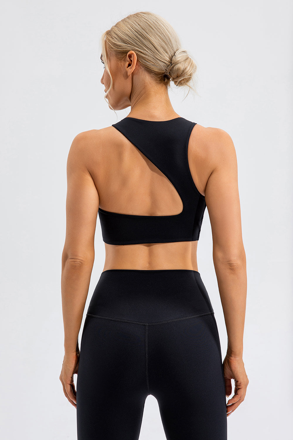 Black asymmetric cutout sports bra with a unique strap detail on the back.