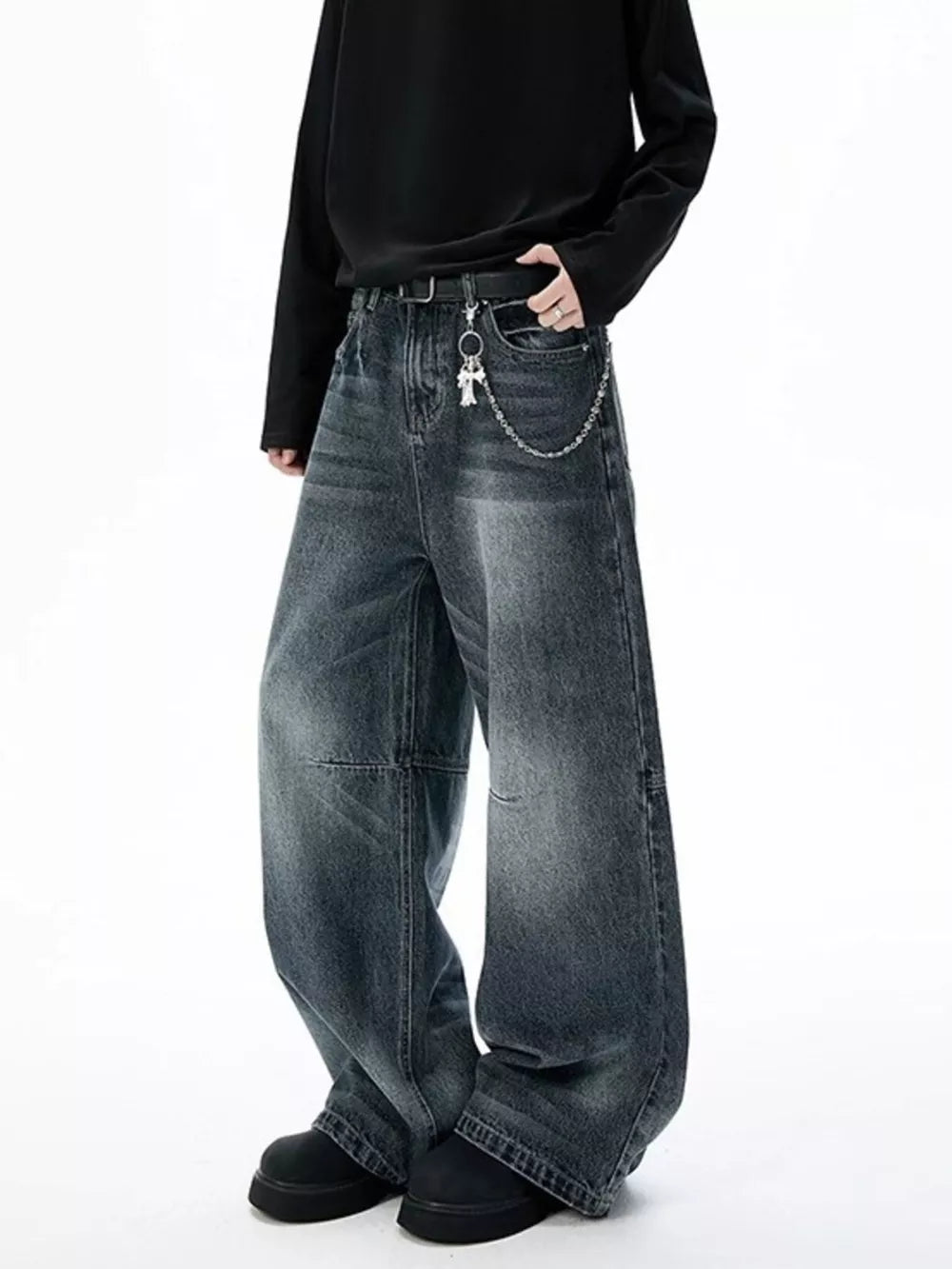 Belted wide-leg jeans in dark wash denim with unique paneled design and chain detail.