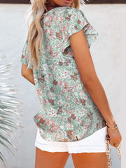 Floral flutter sleeve v-neck blouse in green with pink and white blooms, polyester.