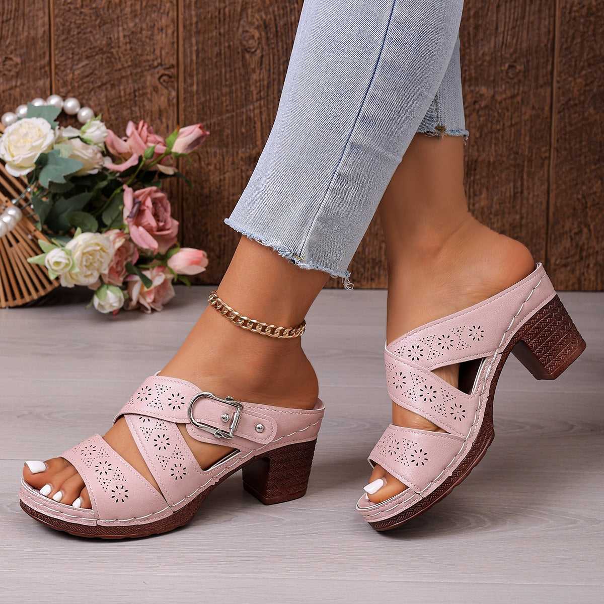 Pink laser-cut criss-cross block heel sandals with buckle detail.