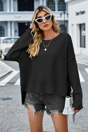 Black acrylic knit sweater with flared sleeves and split hem detail.