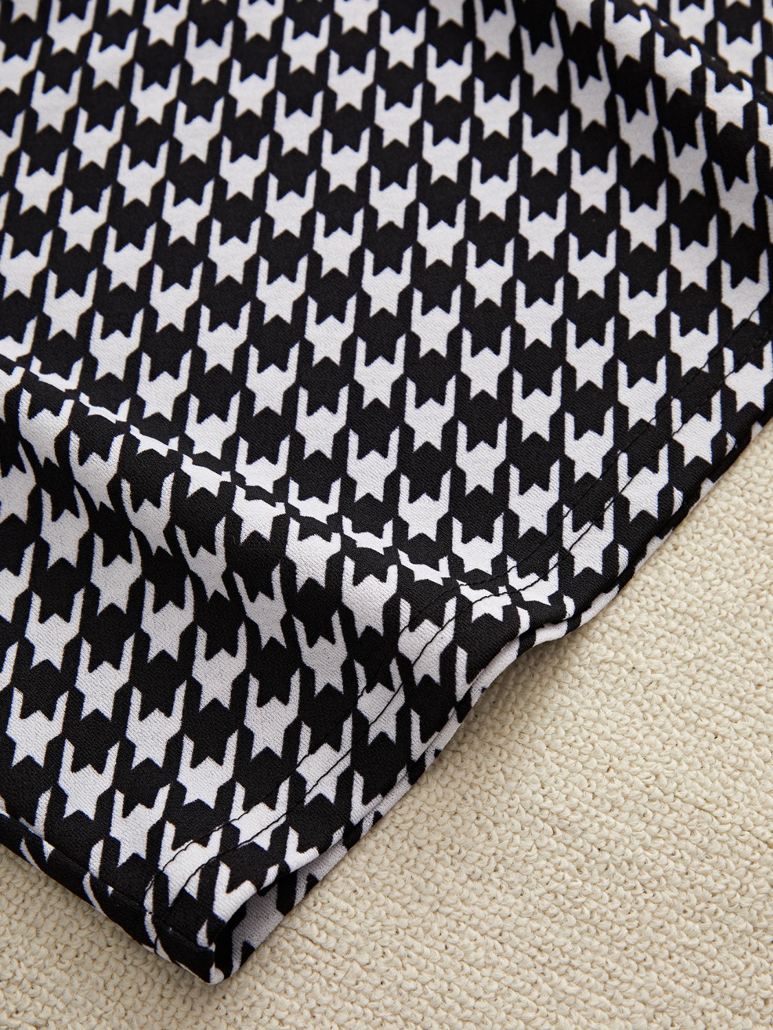 Black houndstooth pencil skirt detail with off-shoulder top fabric texture.