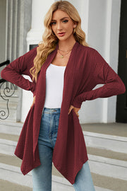 Burgundy textured knit cardigan with asymmetrical drape front and long sleeves.