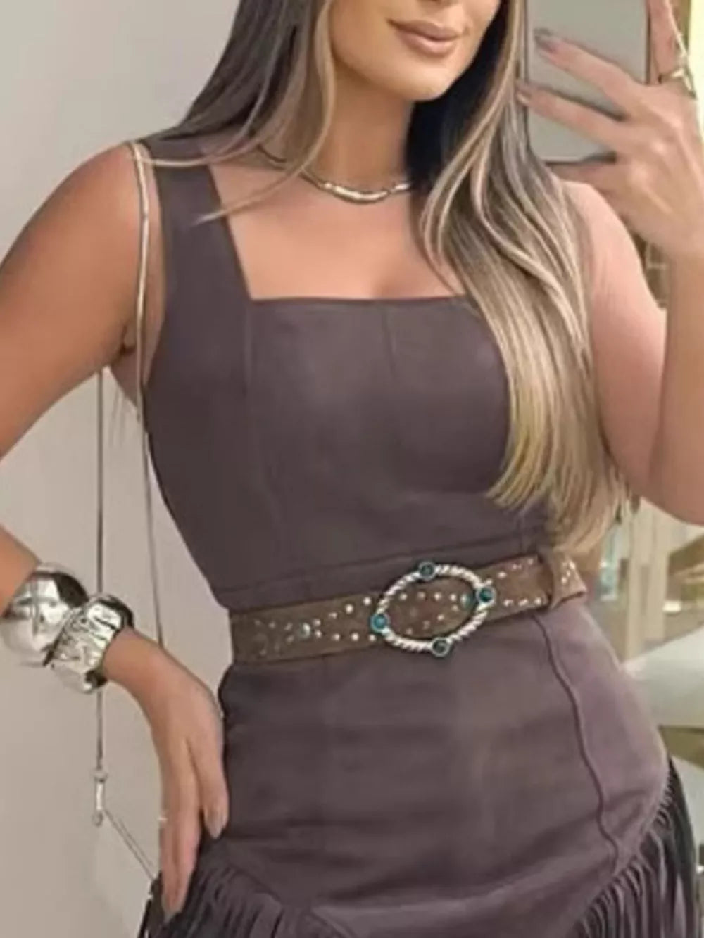 Brown asymmetrical mini dress with fringe detail and square neckline.