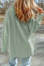 Sage textured shacket with raw-edge detailing and button closure.