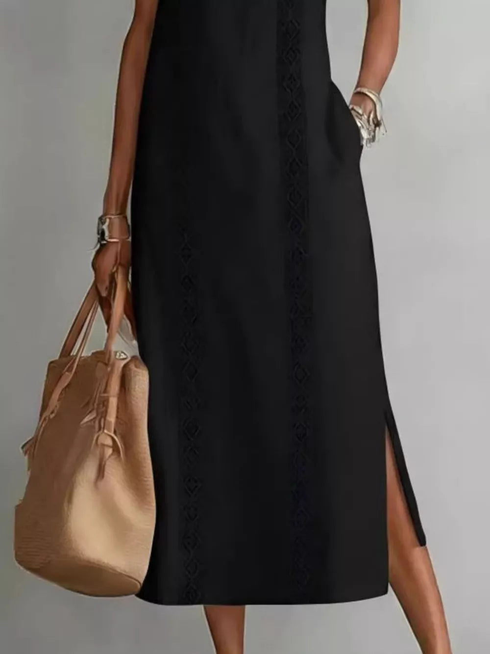Black sleeveless midi dress with geometric trim and side slits, featuring pockets.
