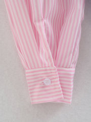 Blush pink and white striped oversized button-down shirt cuff detail with a white button.