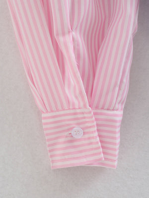 Blush pink and white striped oversized button-down shirt cuff detail with a white button.