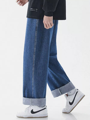 Relaxed wide-leg jeans in dark blue denim with cuffed hems.