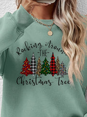 Sage green crewneck sweatshirt with graphic Christmas trees and text.