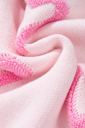 Pink knit sweater with heart appliqué and balloon sleeves.