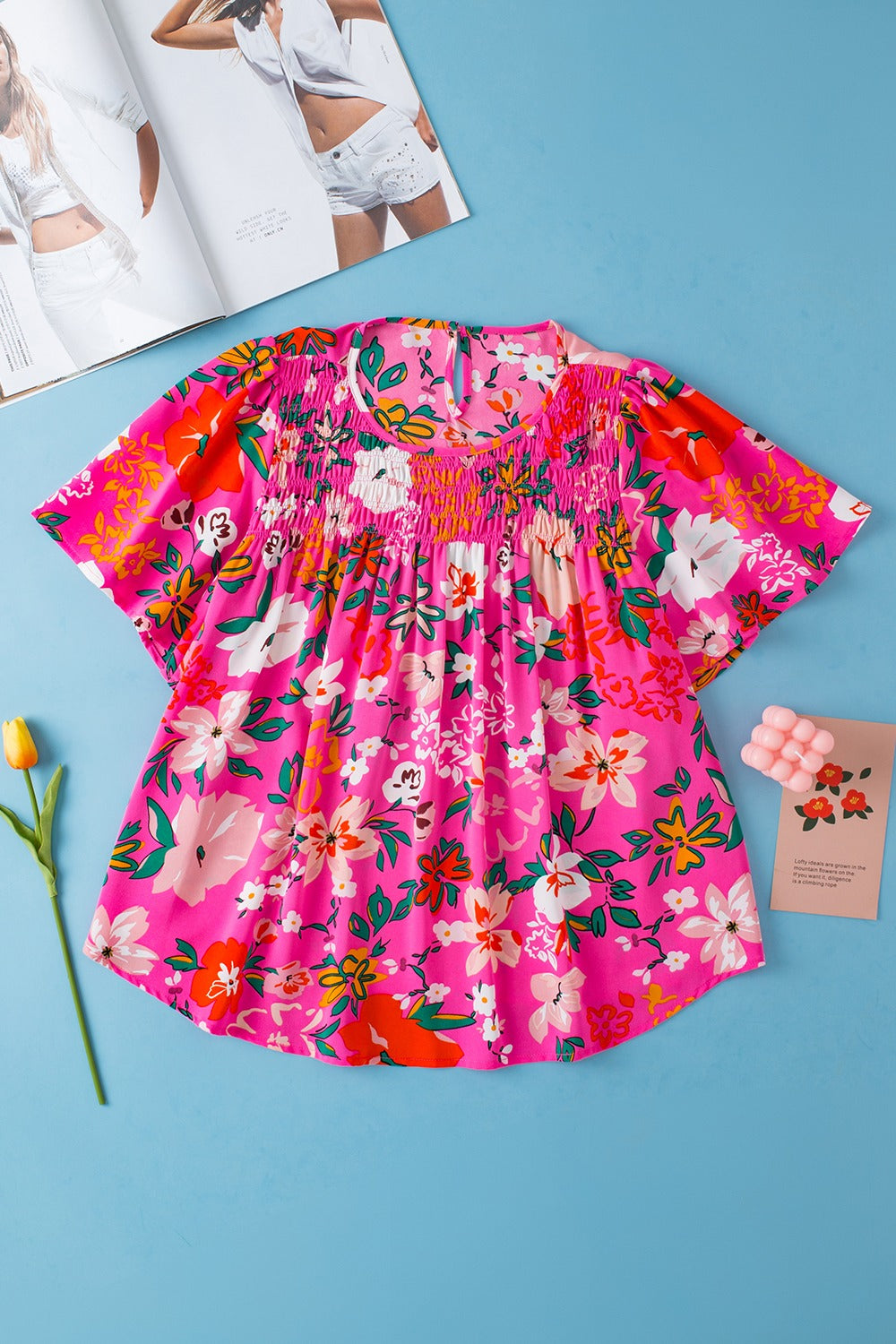 Hot pink floral smocked yoke flutter sleeve blouse with keyhole neckline.