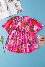 Hot pink floral smocked yoke flutter sleeve blouse with keyhole neckline.