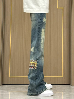 Distressed blue wash wide-leg jeans with patchwork details and ripped accents.