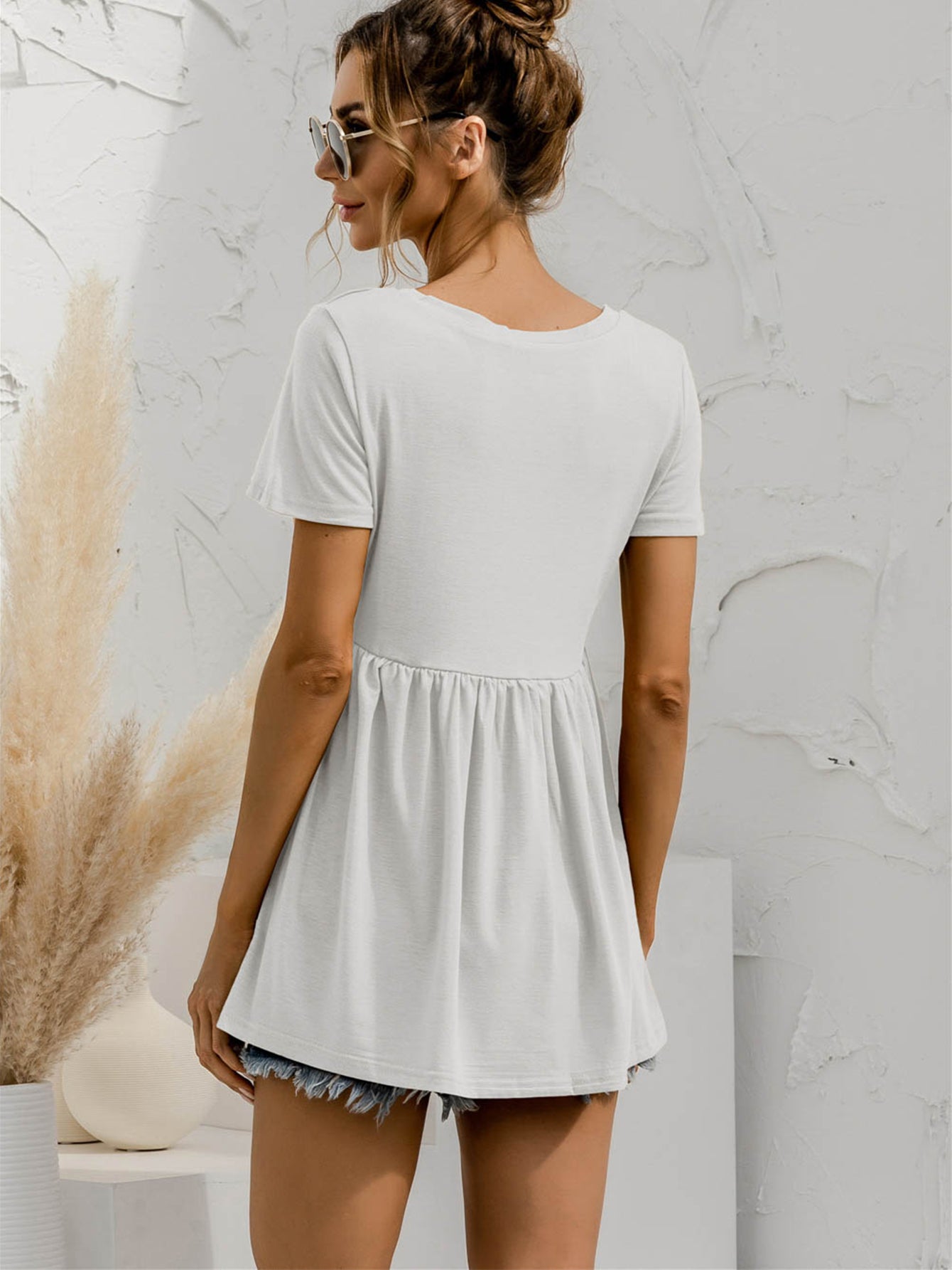 White V-neck tee with gathered waistline and short sleeves, casual babydoll style.