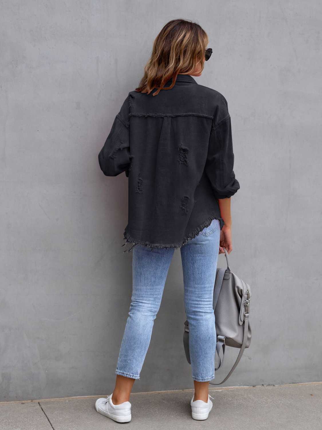 Black distressed denim shacket with frayed hem and cuffs, worn with light wash jeans.